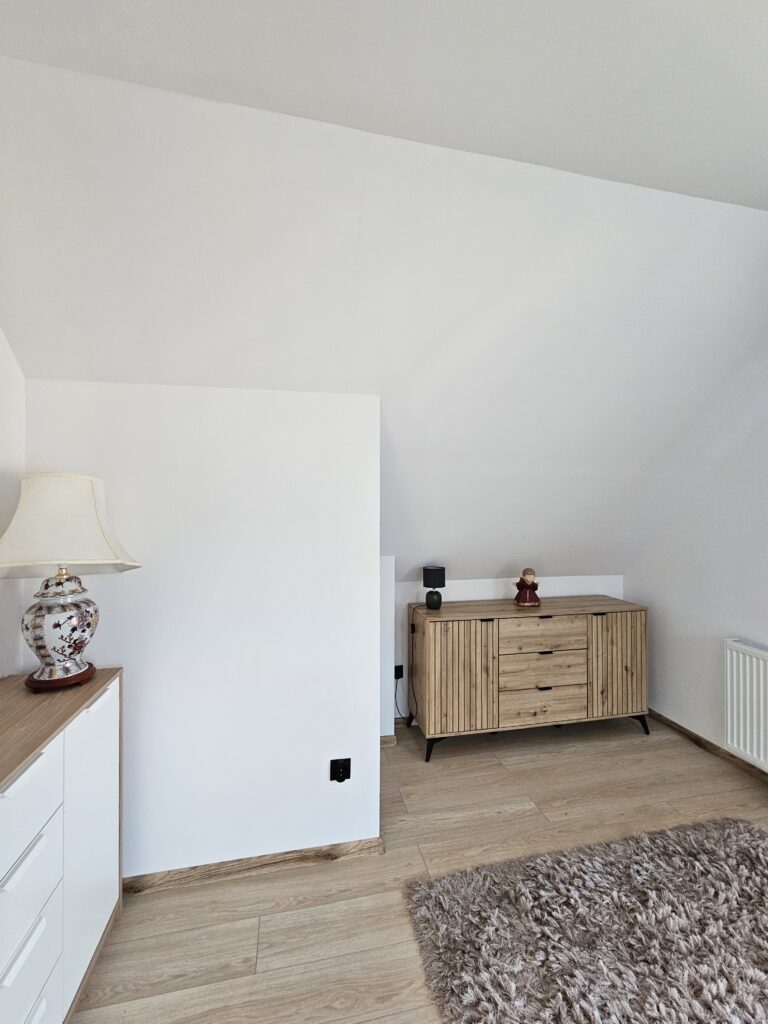 Sypialnia z podwójnym łóżkiem, szafami i balkonem w domu wakacyjnym w Lądku-Zdroju